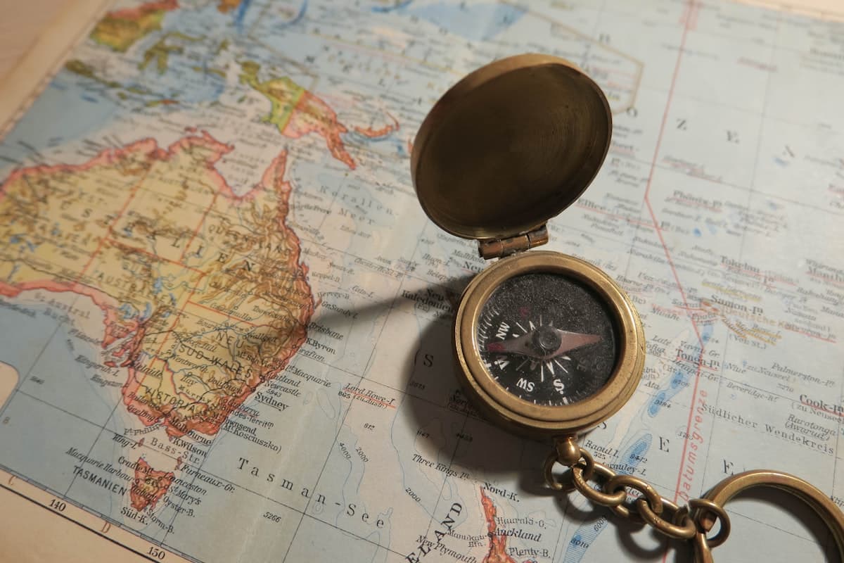 A compass resting on a world map, planning a route