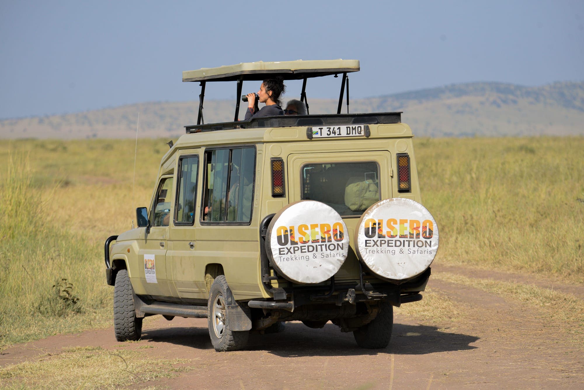 A convoy of Olsero Expedition safari vehicles driving across the plains